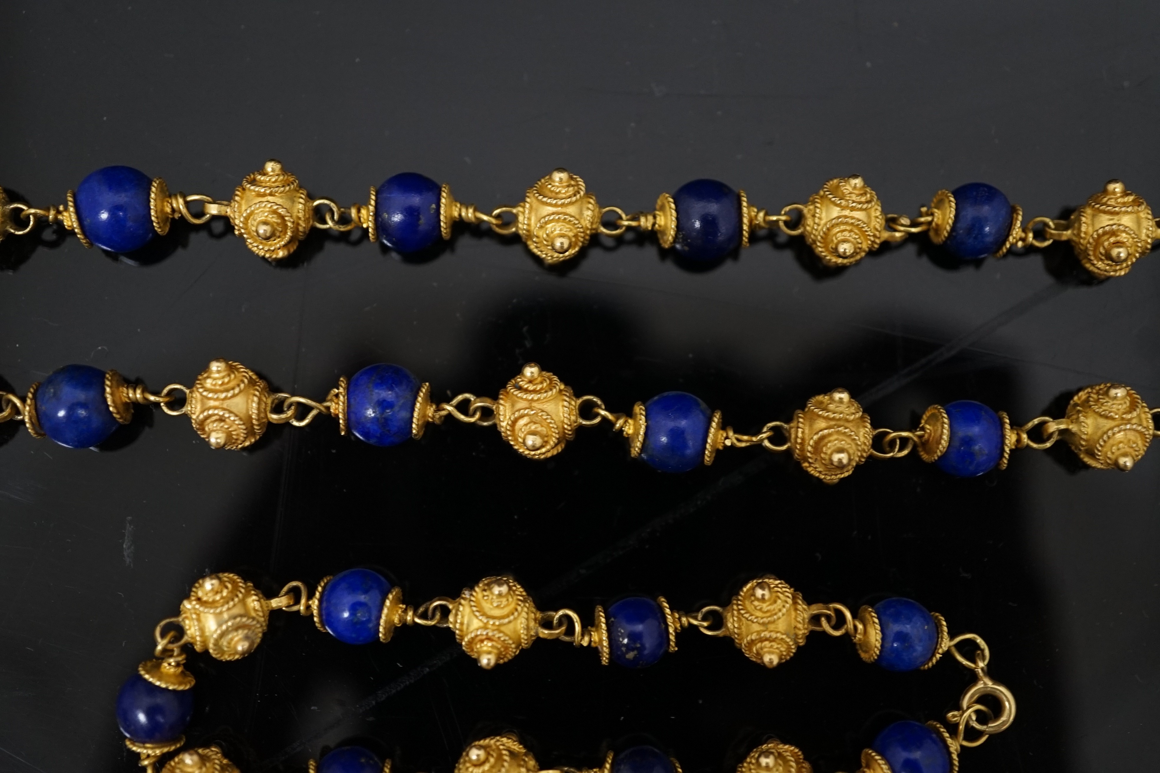 A 20th century Middle Eastern high carat gold canetile work bead and lapis lazuli bead set necklace and matching bracelet